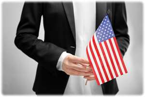 Image of a person's hands holding a United States flag, symbolizing immigration and citizenship